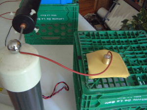 The breakdown voltage/dielectric strength test setup with a
      close-up of the high voltage probe tip touching one terminal of
      the high voltage power supply.