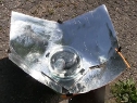 Homemade Copenhagen solar cooker sitting on the ground, cooking.