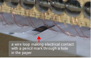 Making electrical contact with through one hole at a time in the 555 timer chip musical instrument.