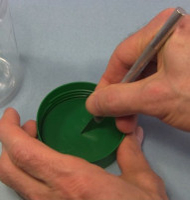 Cutting a dimple in the lid of the corona motor's jar.