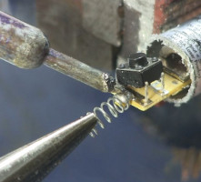 Desoldering the switch and spring from the laser diode circuit.