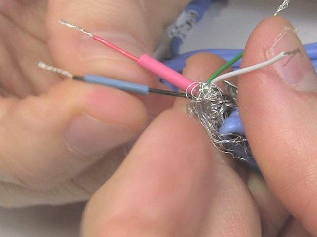 Sliding heat shrink tubing onto a wire in the USB cable.